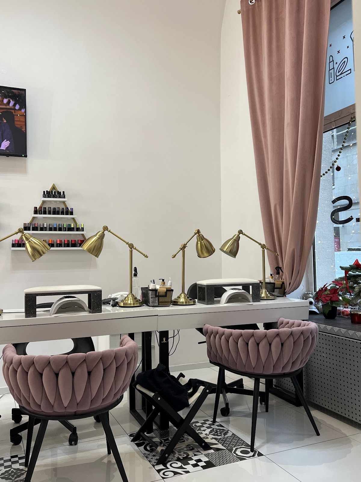 Dwa stanowiska manicure z pudrowymi fotelami i zlotymi lampami